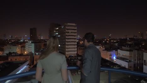 Paar-Auf-Dem-Dach,-Blick-Auf-Tel-Aviv-Bei-Nacht-Und-Trinken-In-Israel