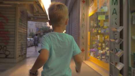 Little-boy-running-on-city-street-in-the-evening