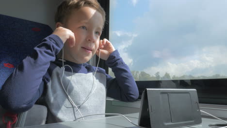 Child-in-train-talking-on-mobile-using-hands-free-set
