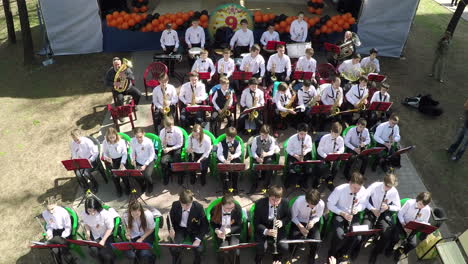 Aerial-view-of-children-wind-instrument-orchestra-performing-in-park