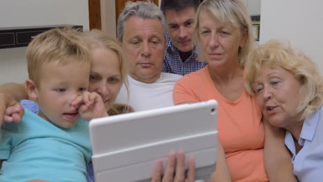 Gran-Familia-Con-Un-Niño-Viendo-Una-Tableta