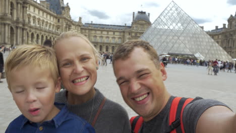 Familia-De-Turistas-Disparándose-Junto-Al-Louvre.