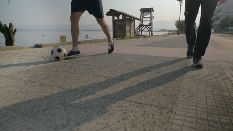 Two-Men-Dribbling-Soccer-Ball-on-the-Footwalk