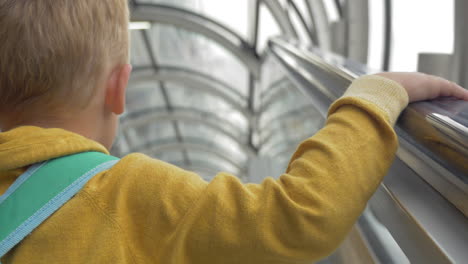 Niño-En-Escalera-Mecánica-Subiendo