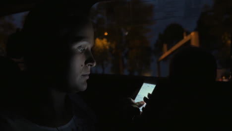 Woman-with-cellphone-in-the-car-at-night