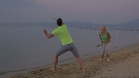 Pareja-Joven,-Entretenerse,-Con,-Tenis,-En-La-Playa