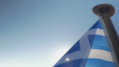 Close-up-Greece-flag-waving-against-sun