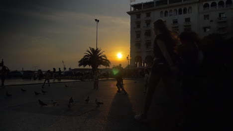 Menschen,-Die-Bei-Sonnenuntergang-Auf-Dem-Platz-Spazieren-Gehen-Und-Spielen