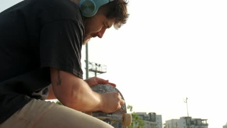 Side-profile-of-an-skateboarder-waxing-his-skateboard