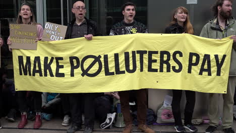 Cinco-Manifestantes-Sostienen-Una-Gran-Pancarta-Amarilla-Que-Dice-&quot;hacer-Que-Los-Contaminadores-Paguen&quot;-En-Una-Protesta-Que-Pide-Medidas-Contra-El-Cambio-Climático.