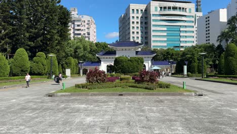 La-Gente-Camina-Por-El-Parque-Espacial-Abierto-Del-Salón-Conmemorativo-De-Chiang-Kai-shek-Y-Contra-El-Fondo-De-La-&quot;puerta-De-La-Gran-Piedad&quot;-En-Taipei,-Taiwán.