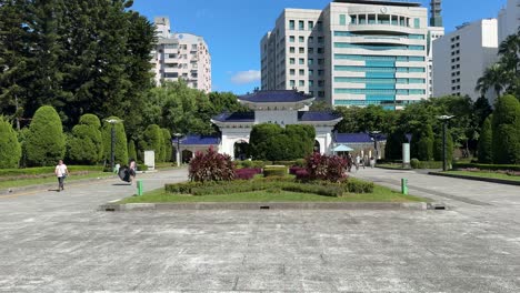 People-walk-around-the-open-space-park-of-Chiang-Kai-Shek-Memorial-Hall-and-against-the-'Gate-of-Great-Piety'-background-in-Taipei,-Taiwan