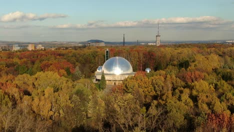 Aerial-side-panning-shot-Silesian-Planetarium-in-the-middle-of-Park-in-Chorzow,-Poland