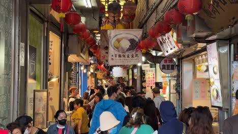 Tourists-explore-the-bustling-Jiufen-Old-Street,-known-for-its-narrow-streets,-food-stalls,-and-tea-houses-in-New-Taipei-City's-Ruifang-District,-Taiwan