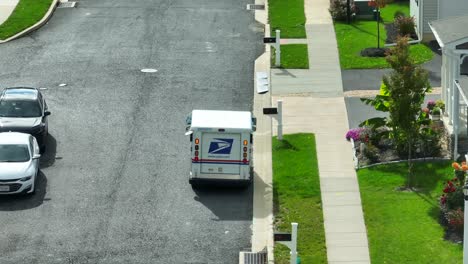 USPS-truck-driving-through-suburban-neighborhood-delivering-mail