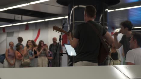 Band-of-young-male-musicians-playing-to-crowd-of-people