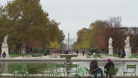 Brunnen-Und-Pariser-Gehen-Im-Place-Du-Carrousel-Garden-Mit-Arc-De-Triomphe-In-Der-Ferne-Spazieren