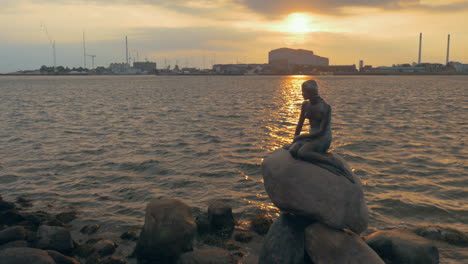 Mermaid-statue-on-city-waterside-at-sunset