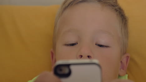 Close-up-shot-of-little-boy-playing-a-game-on-the-smartphone