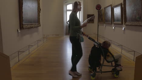 Mujer-Y-Niño-Caminando-Por-Los-Pasillos-Del-Museo-Del-Louvre.