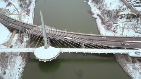 Overhead-4K-Winter-Drone-Shot-of-Amazing-Architecture-Tower-Provencher-Bridge-Over-the-Red-Assiniboine-River-in-Downtown-Winnipeg-Manitoba-Canada