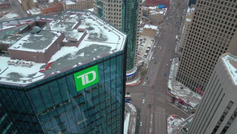 Große-Höhe,-4k-Winter,-Nördliche-Drohnenaufnahme-Der-Schilderaußenseite,-Hochhaus-Wolkenkratzer,-Hauptsitz-Der-Toronto-Dominion-Bank-Mit-Portage-Hauptstraße-In-Der-Innenstadt-Von-Winnipeg,-Manitoba,-Kanada