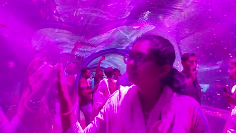 Young-and-beautiful-girl-touching-fish,-people-watching-fish-in-underwater-tunnel