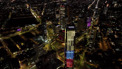 Aerial-view-backwards-away-from-the-Colpatria-tower,-night-in-Bogota,-Colombia