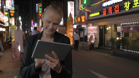 Mujer-Usando-Un-Panel-Táctil-En-Las-Calles-De-Seúl-Por-La-Noche,-Corea-Del-Sur