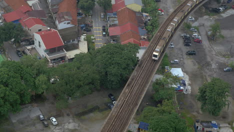 Vista-De-Pájaro-Del-Distrito-Pobre-Y-Montar-En-Tren-En-Los-Ferrocarriles-Bangkok,-Tailandia