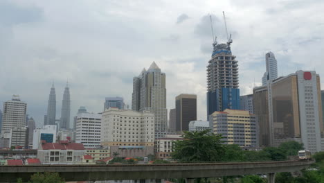 Vista-Del-Tren-En-Primer-Plano-Y-Rascacielos-De-Edificios-Modernos-En-El-Fondo-Kuala-Lumpur-Malasia
