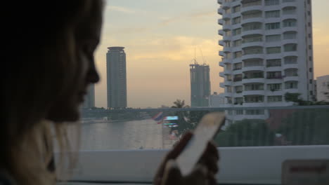 Mujer-Enviando-Mensajes-De-Texto-Al-Celular-Durante-Un-Viaje-En-Autobús-En-Bangkok,-Tailandia