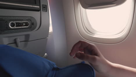 Frau-Entfaltet-Hausschuhe-Im-Flugzeug