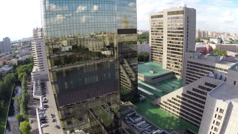 Airplane-view-on-city-reflection-in-mirror-facade-of-building