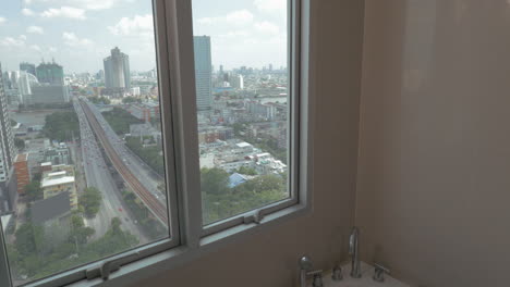 In-Der-Stadt-Bangkok,-Thailand,-Junges-Mädchen-In-Einer-Wohnung-Am-Fenster,-Das-Ein-Bad-Nimmt