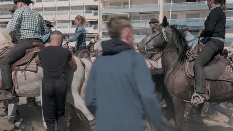 Toma-Cinematográfica-En-Cámara-Lenta-De-Pasos-Majestuosos-De-Caballos-Con-Sus-Jinetes-En-La-Playa-Durante-El-Desfile-De-Feria-Palavas.