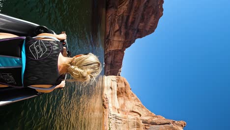 Vertical---Woman-Boating-On-Lake-Powell-With-View-Majestic-Rock-Walls