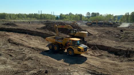 Camión-Volquete-De-Carga-De-Excavadora-Con-Suelo-Excavado-En-Preparación-Para-El-Sitio-De-Construcción