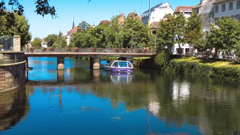 Malerische-Kleine-Brücke-über-Die-Ill-In-Petite-France---Darunter-Segelndes-Straßburger-Boot