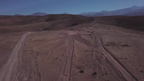 A-car-driving-through-the-wild-deserted-landscape-of-Atacama-desert,-Chile,-Scenic-road-journey,-Bolivia