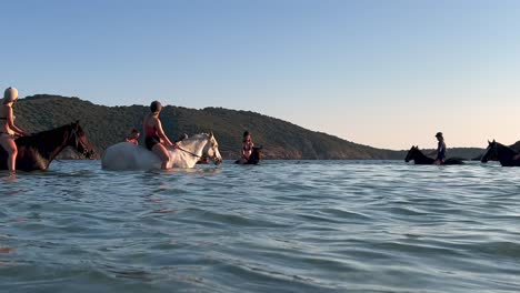 Während-Der-Sommersaison-Genießen-Touristen-Das-Baden-Beim-Reiten-Ohne-Sattel-Im-Meerwasser