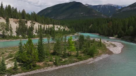 Rising-drone-shot-looking-at-the-pristine-and-clean-Kootenay-River-with-mountains-and-a-small-forest-fire-burning-in-the-background