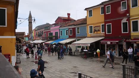 Paseo-Turístico-Por-La-Calle-Burano-De-Casas-Coloridas,-Mira-Las-Tiendas-De-Souvenirs-En-Un-Día-Lluvioso,-Venecia,-Italia