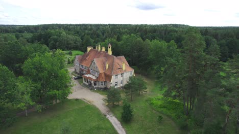 Drone-shot-of-mansion-that-is-surrounded-by-green-forest