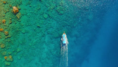 Aerial-top-down-4K-drone-view-of-a-boat-riding-to-the-Suluada-Island-in-Adrasan-Sea,-Antalya-–-Turkey