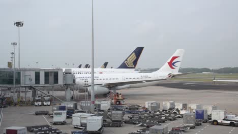 Airplanes-and-lugage-cargo-at-the-terminal-of-Changi-airport,-singapore