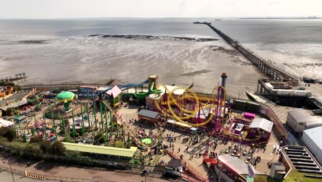 Southend-on-Sea-Adventure-Island-Pier-Static-drone-hover-shows-rollercoaster-and-rides-with-people-mingling