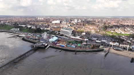 Adventure-Island-Y-Southend-Pier-Desde-El-Aire,-Un-Amplio-Barrido-De-Drones-Muestra-Todo-El-Sitio-Del-Parque-Temático,-La-Sección-Del-Famoso-Muelle-Y-Las-Torres-Y-La-Ciudad-Más-Allá.