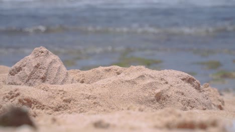 Nahaufnahme-Fokussierter-Sandstrand-Verschwommene-Meereswellen