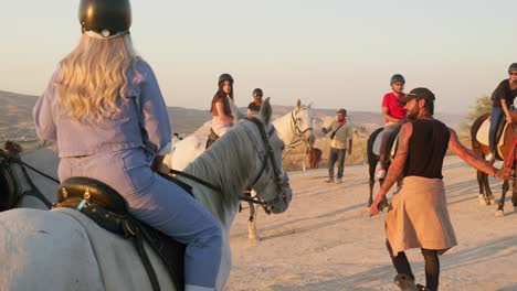 Reitführer-Bei-Sonnenuntergang-Führt-Freunde-Einer-Pferdetouristengruppe